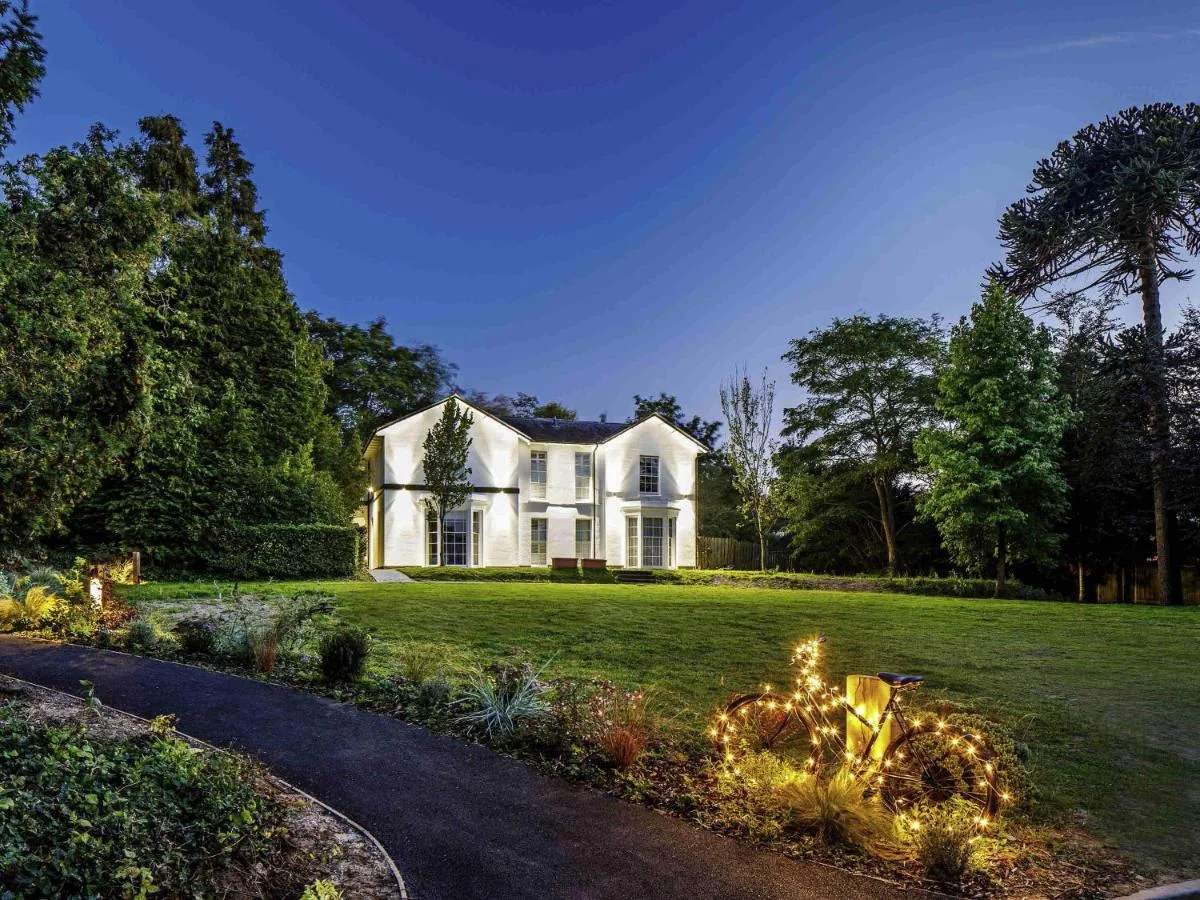 a white house with christmas lights in the yard at Mercure Oxford Hawkwell House Hotel in Oxford